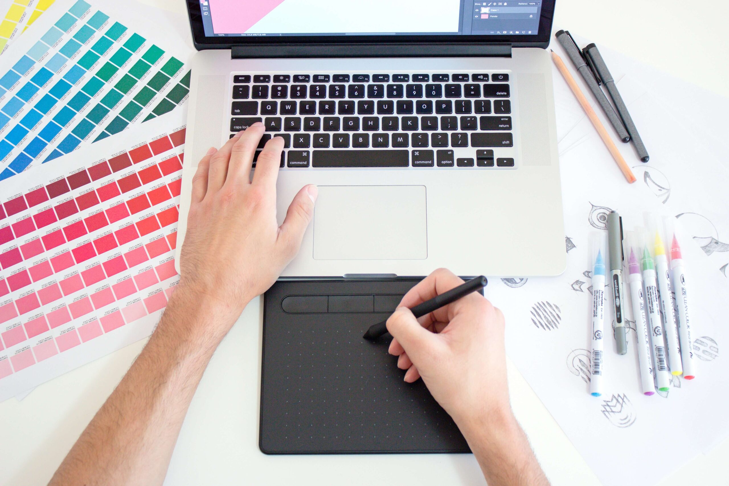 Person designing on a laptop with color swatches in background